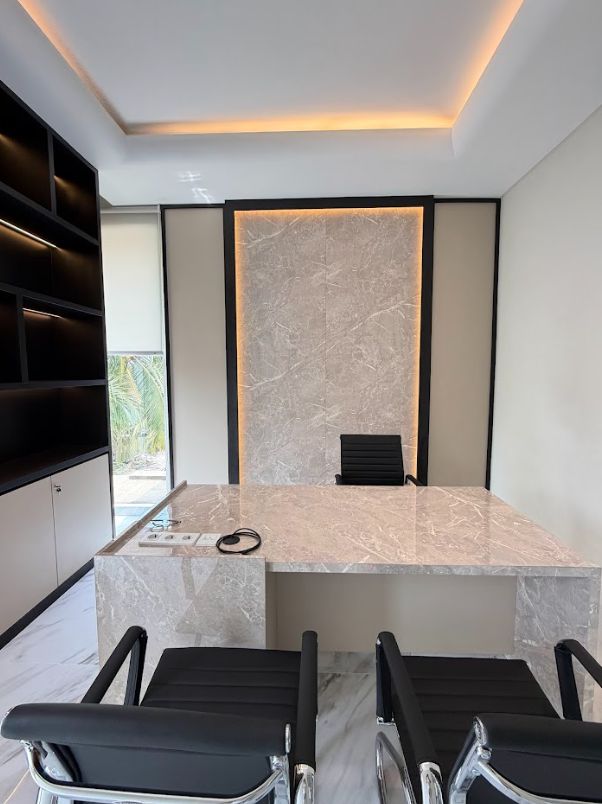 Proyek interior kantor eksklusif dengan fokus pada backdrop granit dan pencahayaan emas melingkar.