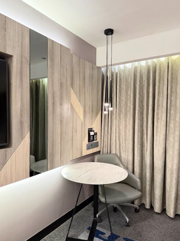 Interior Novotel Jogja dengan gorden, meja bulat, kursi dan cermin
